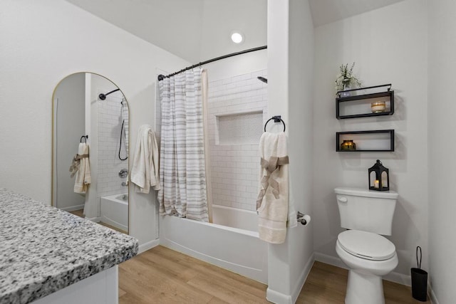 bathroom featuring toilet, shower / tub combo with curtain, wood finished floors, and baseboards