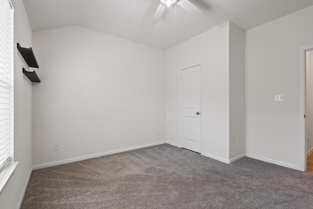carpeted spare room featuring ceiling fan, lofted ceiling, and baseboards