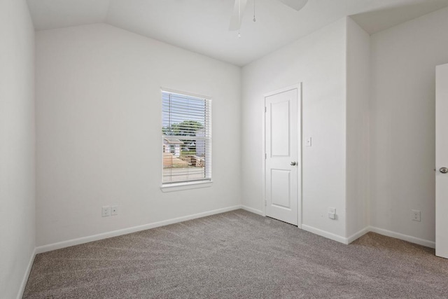 carpeted spare room featuring baseboards, a ceiling fan, and vaulted ceiling