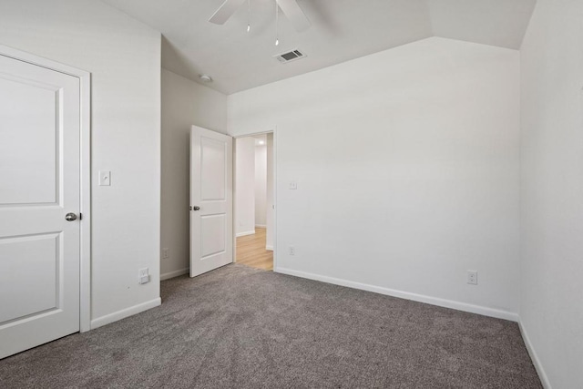 unfurnished bedroom with carpet, vaulted ceiling, baseboards, visible vents, and a ceiling fan