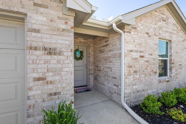 doorway to property with brick siding