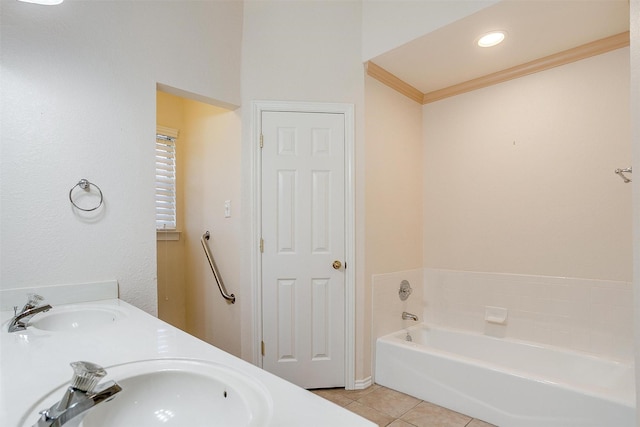 full bathroom featuring a bath, ornamental molding, tile patterned flooring, and a sink