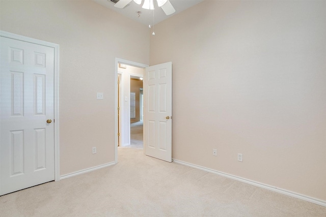 unfurnished bedroom featuring carpet floors, a ceiling fan, a towering ceiling, and baseboards