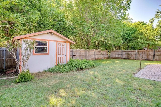 view of yard featuring a fenced backyard, an outbuilding, and a shed