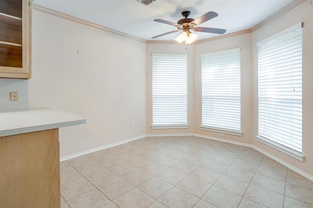 unfurnished dining area featuring ceiling fan, baseboards, ornamental molding, and light tile patterned flooring