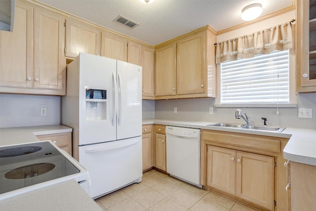 kitchen with light brown cabinetry, a sink, visible vents, white appliances, and light countertops
