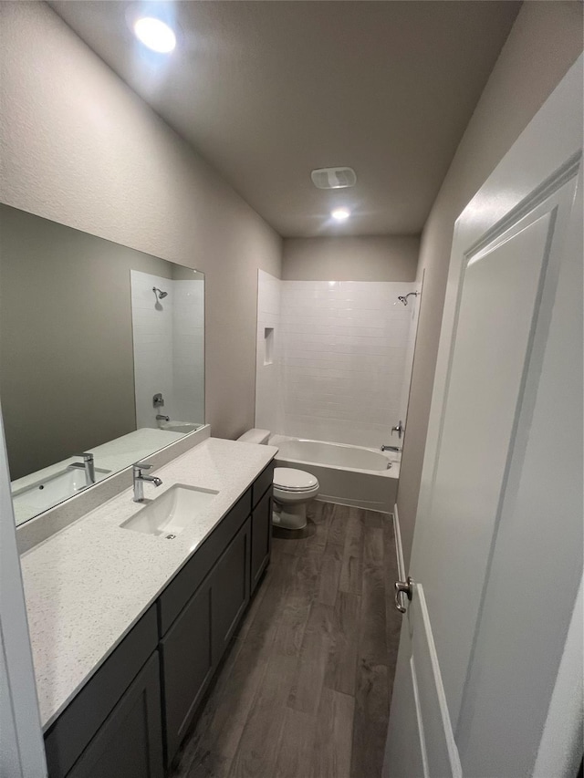 full bath featuring toilet, recessed lighting, wood finished floors, vanity, and shower / tub combination