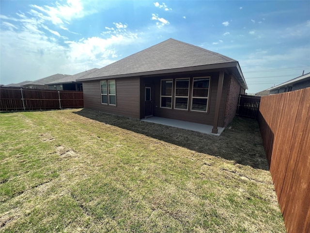 back of house with a lawn, a patio, and a fenced backyard