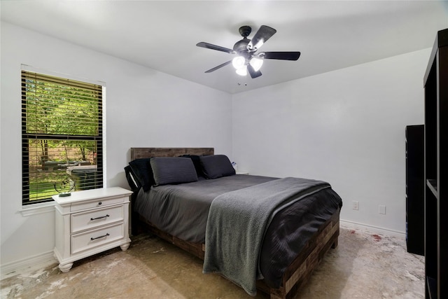 bedroom featuring a ceiling fan, baseboards, and unfinished concrete flooring