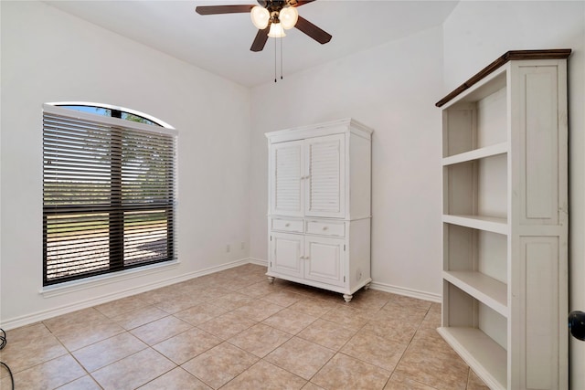 unfurnished bedroom featuring ceiling fan, multiple windows, and light tile patterned floors