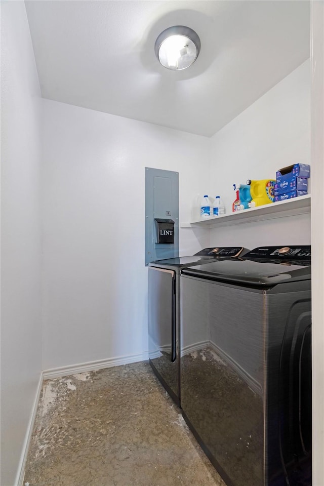 laundry area with baseboards, laundry area, washer and clothes dryer, and electric panel