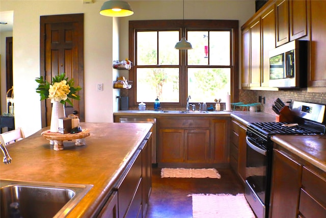 kitchen featuring backsplash, appliances with stainless steel finishes, brown cabinetry, and a sink