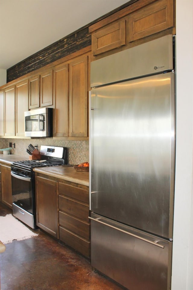 kitchen with concrete flooring, tasteful backsplash, and stainless steel appliances