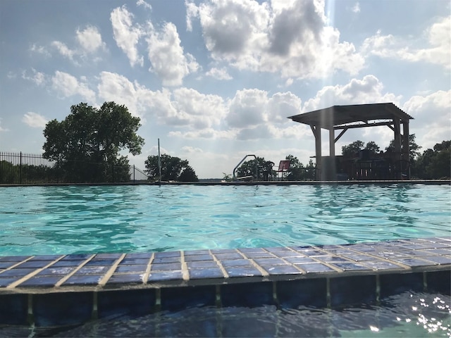 view of dock featuring a community pool and fence