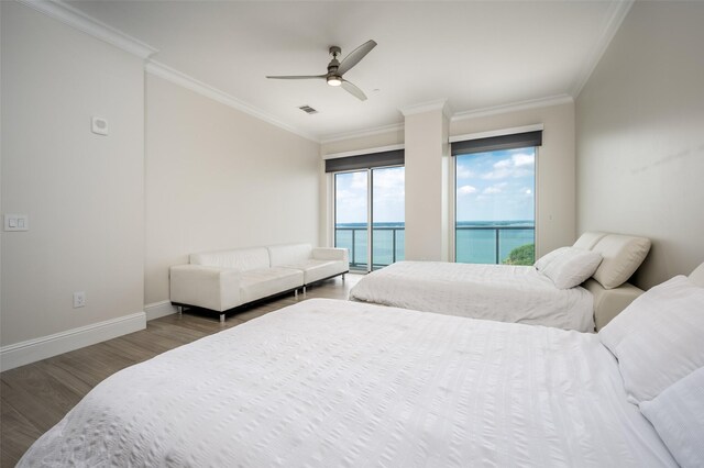 bedroom with wood finished floors, visible vents, ornamental molding, and a ceiling fan