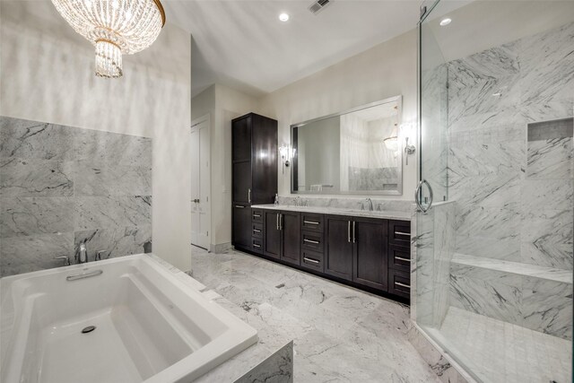 bathroom featuring a bath, a marble finish shower, a notable chandelier, and a sink