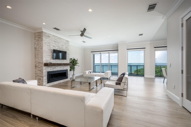 living room with visible vents, a wealth of natural light, and crown molding