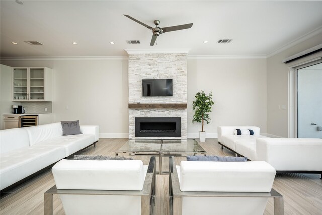 living area with wood finished floors, visible vents, a ceiling fan, and baseboards
