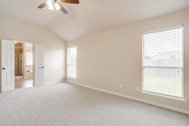 spare room featuring baseboards, a ceiling fan, lofted ceiling, and light carpet