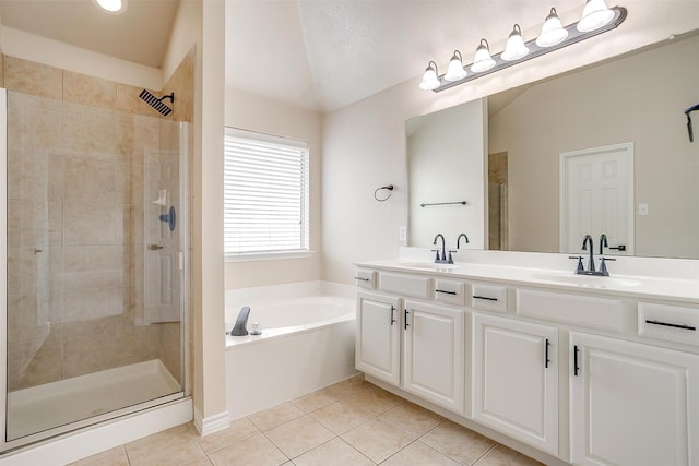 full bath featuring tile patterned floors, a shower stall, a sink, and a garden tub