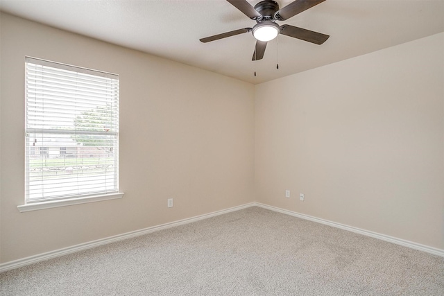 carpeted empty room with baseboards and a ceiling fan