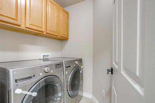 washroom with cabinet space, separate washer and dryer, baseboards, and tile patterned flooring