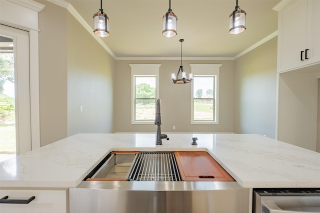 kitchen featuring crown molding, light stone counters, a sink, an inviting chandelier, and white cabinets