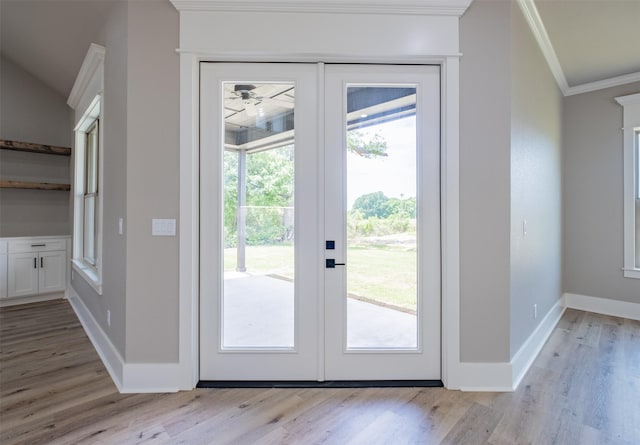 doorway with light wood-type flooring, baseboards, ornamental molding, and french doors