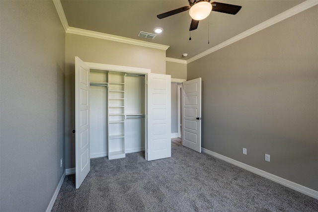 unfurnished bedroom featuring baseboards, visible vents, dark carpet, a closet, and crown molding