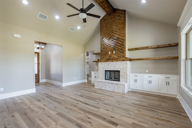unfurnished living room with light wood finished floors, a ceiling fan, visible vents, and high vaulted ceiling
