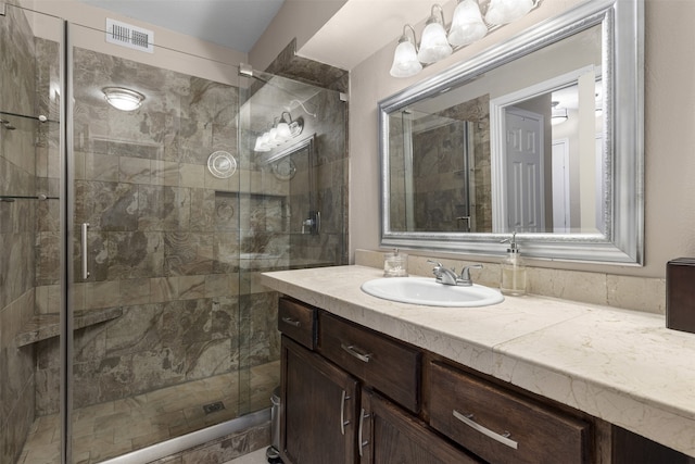 bathroom with visible vents, vanity, and a stall shower