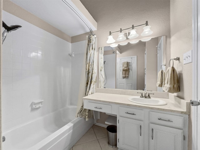 full bath with tile patterned floors, shower / tub combo with curtain, a textured wall, and vanity