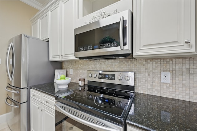 kitchen featuring dark stone counters, tasteful backsplash, white cabinets, and stainless steel appliances