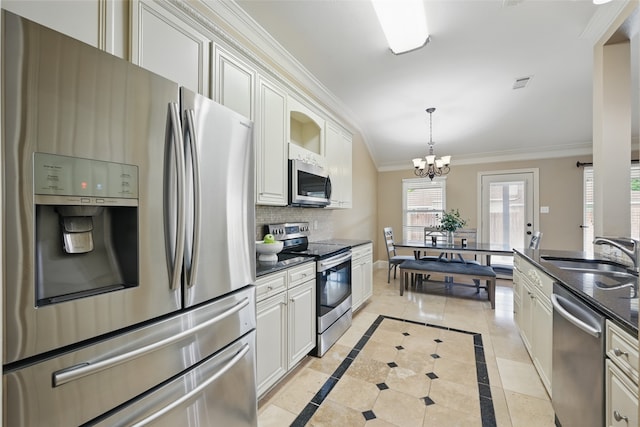 kitchen featuring a sink, appliances with stainless steel finishes, crown molding, and white cabinetry