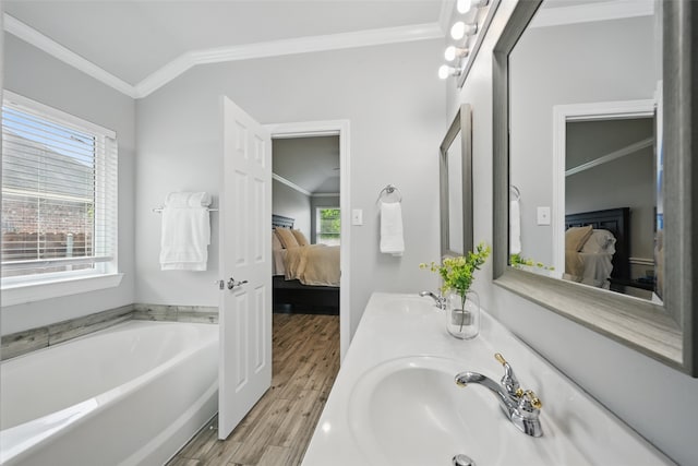 ensuite bathroom featuring crown molding, wood finished floors, a sink, and ensuite bath