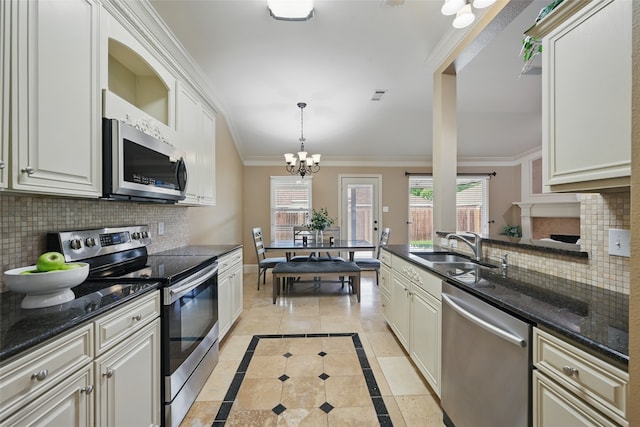 kitchen featuring backsplash, a sink, a chandelier, ornamental molding, and stainless steel appliances