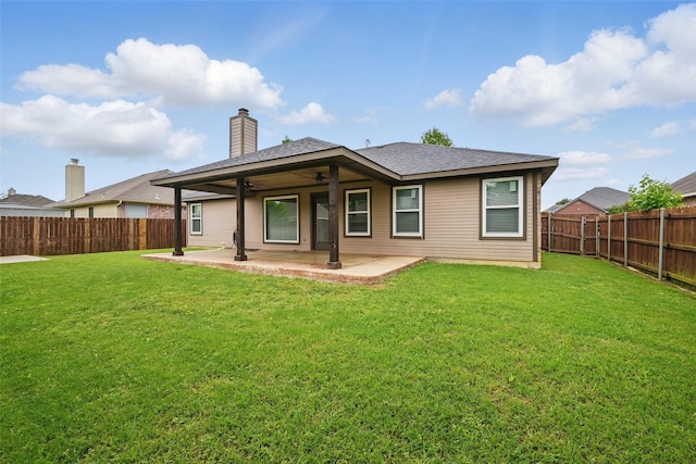 rear view of house with a lawn, a patio, ceiling fan, and a fenced backyard