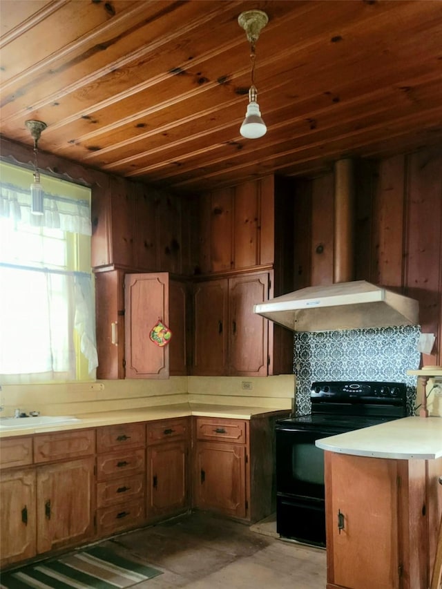 kitchen with brown cabinets, light countertops, black range with electric stovetop, a sink, and pendant lighting