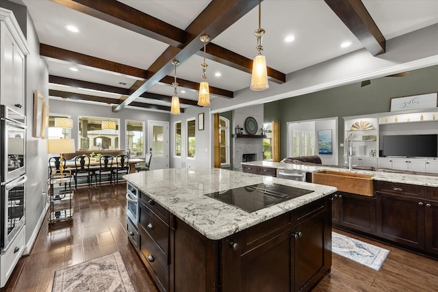 992 Anna Cade Rd, Rockwall, TX 75087 - kitchen with stainless steel appliances, open floor plan, a sink, beamed ceiling, and a fireplace