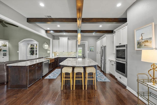 992 Anna Cade Rd, Rockwall, TX 75087 - kitchen with appliances with stainless steel finishes, a sink, beamed ceiling, dark wood finished floors, and a kitchen bar