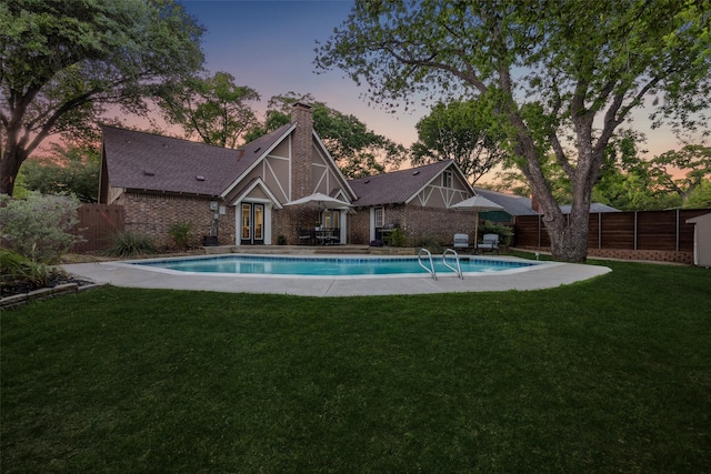 view of pool featuring a fenced in pool, a yard, french doors, and a fenced backyard