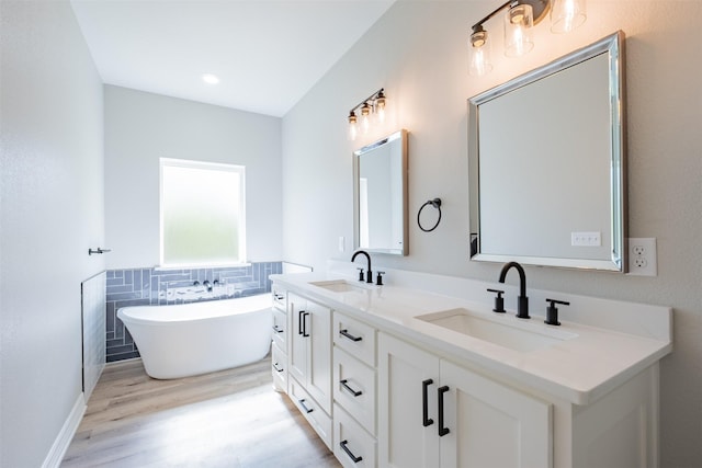 14835 Fallow Ln, Tyler, TX 75706 - full bathroom featuring double vanity, wood finished floors, a sink, and a freestanding bath