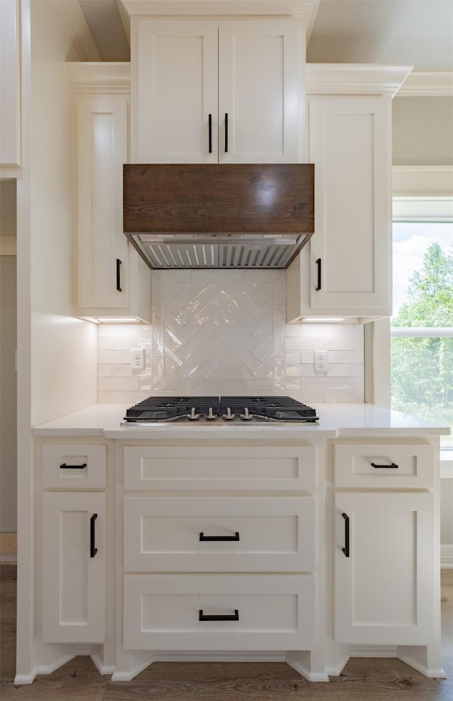 14835 Fallow Ln, Tyler, TX 75706 - kitchen featuring backsplash, wall chimney exhaust hood, white cabinetry, and light countertops