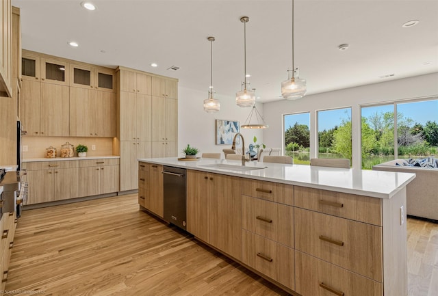 kitchen with stainless steel dishwasher, a sink, light brown cabinetry, light wood-style floors, and light countertops