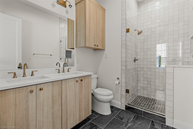 bathroom featuring a stall shower, a sink, double vanity, and toilet