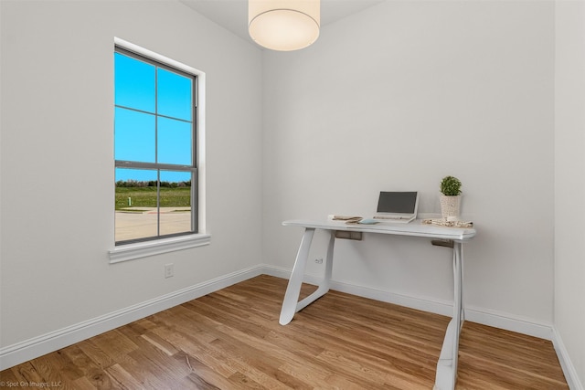 unfurnished office with baseboards and wood finished floors