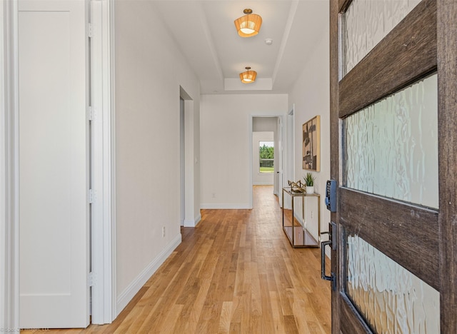 corridor featuring baseboards and light wood-style floors