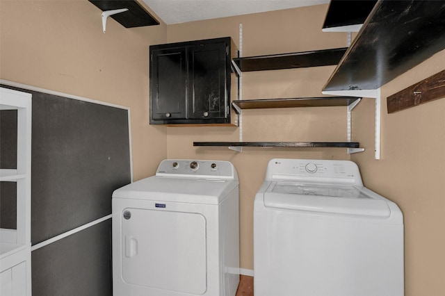 laundry area featuring washing machine and clothes dryer and cabinet space