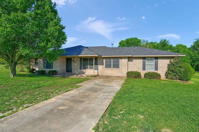 single story home with brick siding, a front yard, and concrete driveway