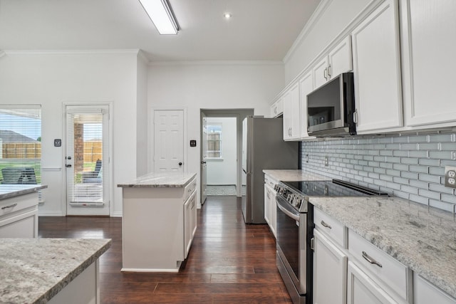 kitchen featuring crown molding, stainless steel appliances, white cabinetry, and tasteful backsplash